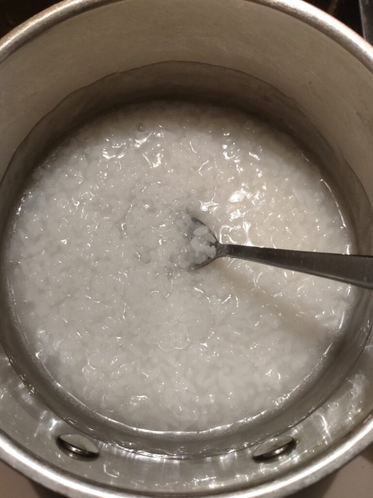 鍋で炊き上がったお粥にスプーンを入れた状態