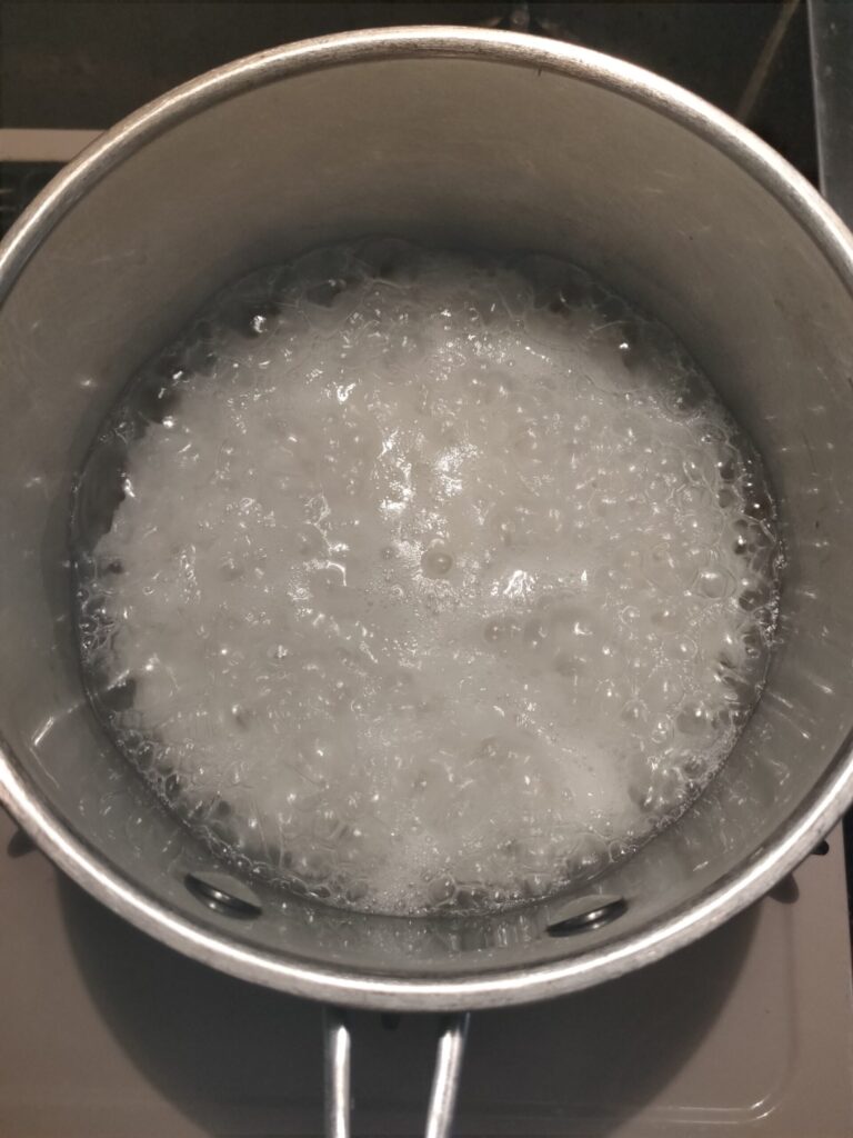 鍋でごはんと水を加熱し、お粥が沸騰している様子