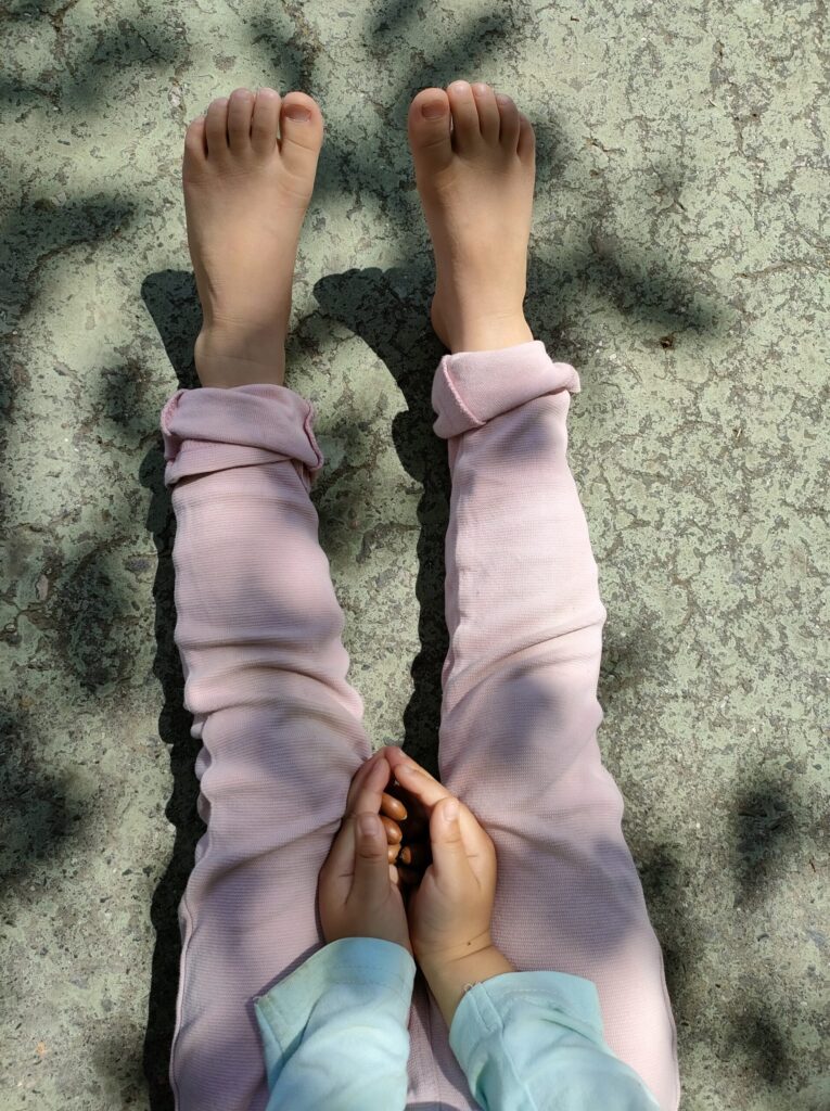 どんぐりを持つ子どもの手と足元の様子