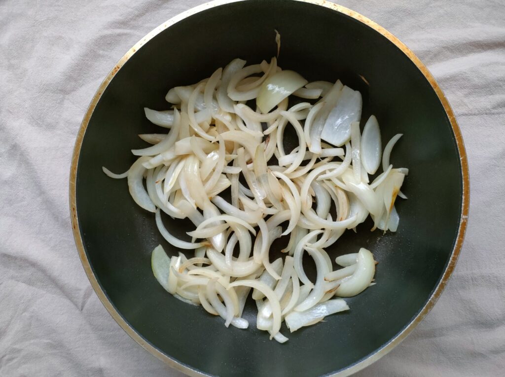 フライパンで薄切り玉ねぎを炒めている様子