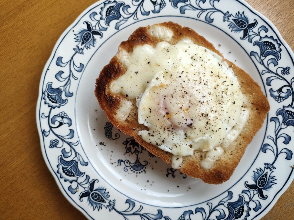 食パンに電子レンジで作った卵とチーズをのせて焼き、黒こしょうをふったところ