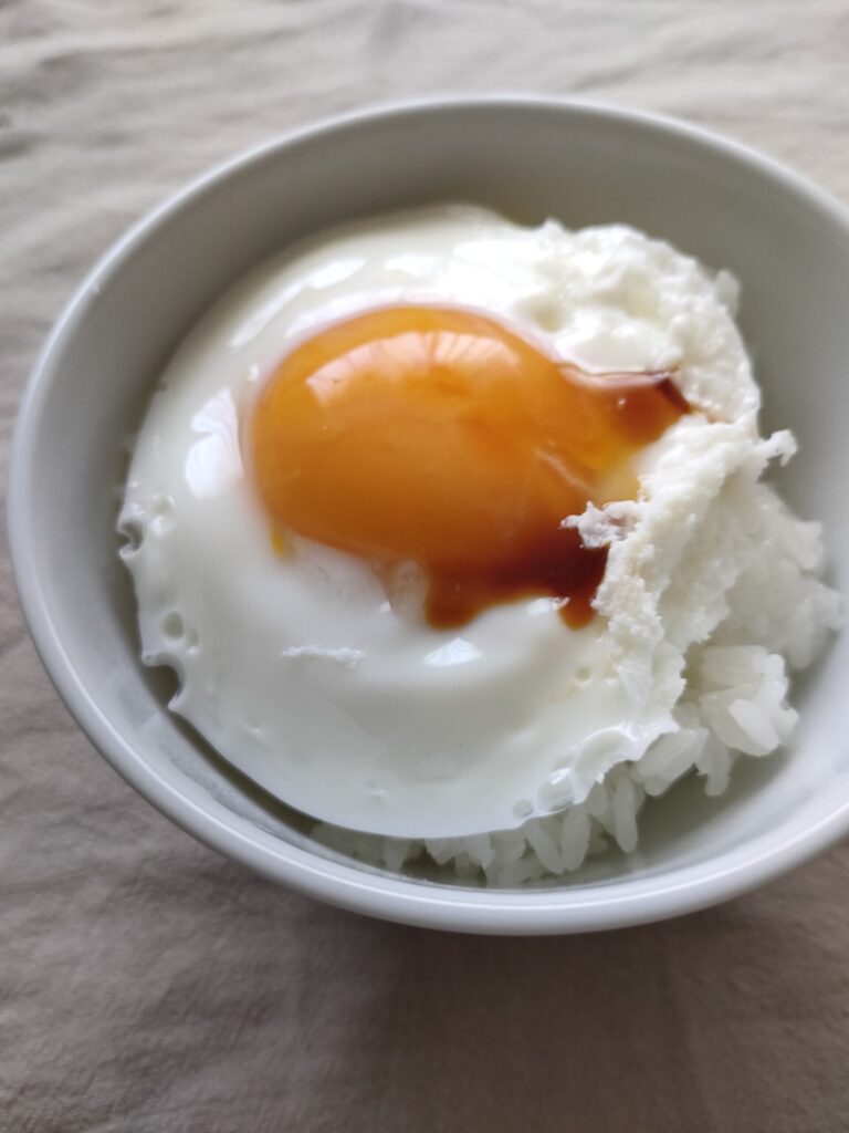 ご飯に電子レンジで作った卵をのせ、しょうゆをかけたところ