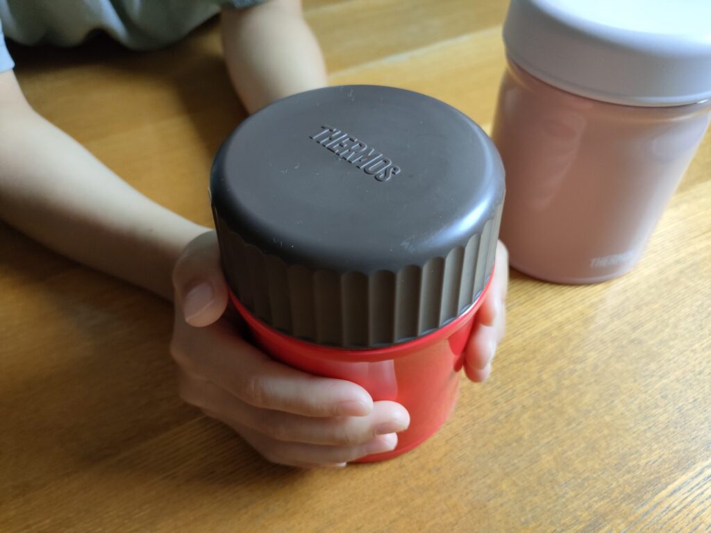 学童のお弁当用に持って行くスープジャーを子どもが持っている様子 